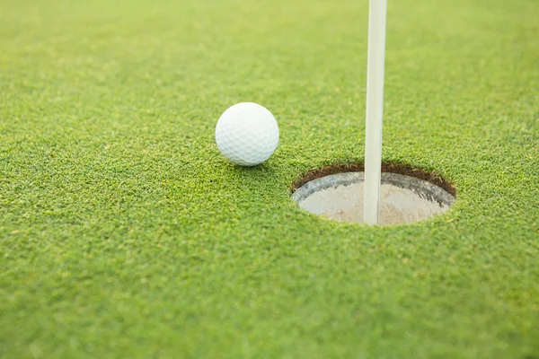 Golf ball at the edge of the hole — Stock Photo, Image