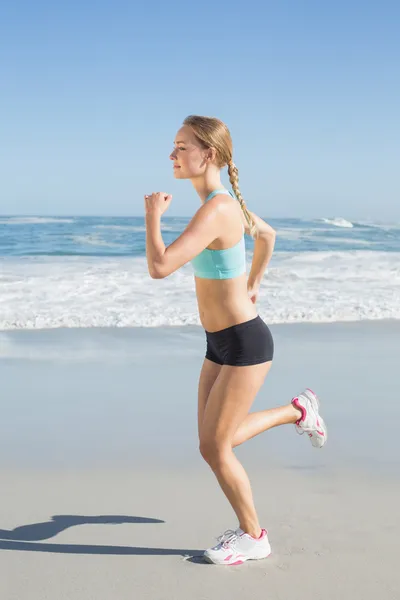 Ajuste jogging loira na praia — Fotografia de Stock
