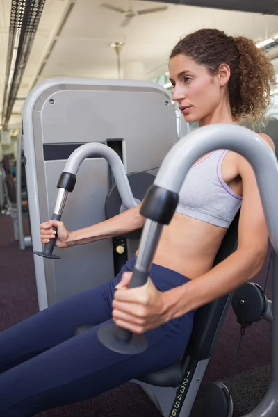 Fit woman using the weights machine — Stock Photo, Image