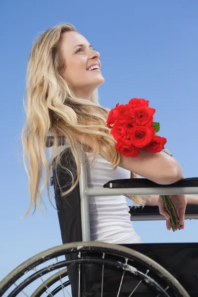Rolstoel gebonden blonde bedrijf rozen — Stockfoto