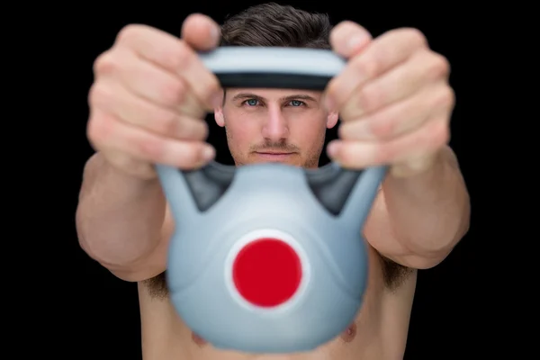 Focused bodybuilder lifting up kettlebell — Stock Photo, Image