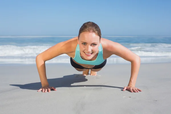 Femme en position de planche sur la plage — Photo