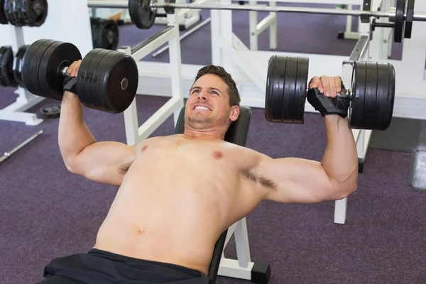 Shirtless bodybuilder tillen van zware halters — Stockfoto