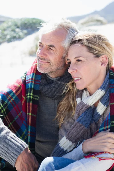 Couple enveloppé dans une couverture sur la plage — Photo