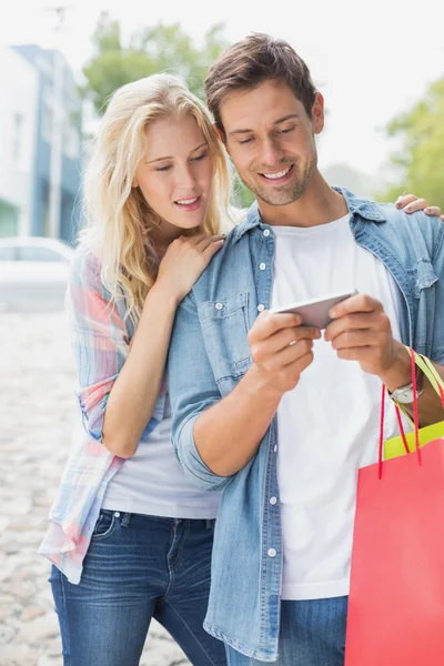 Coppia guardando smartphone durante il viaggio di shopping — Foto Stock