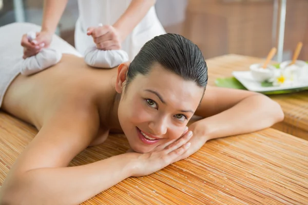 Brunette getting a herbal compress massage — Stock Photo, Image
