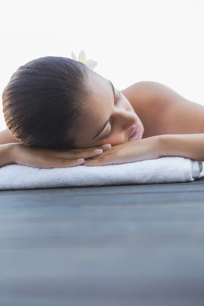 Calm brunette lying on a towel poolside — Stock Photo, Image