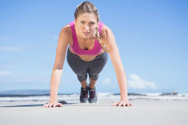 Blondine in Plankenstellung am Strand — Stockfoto