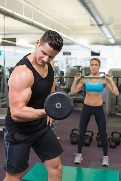 Muscular man and woman lifting weights — Stock Photo, Image