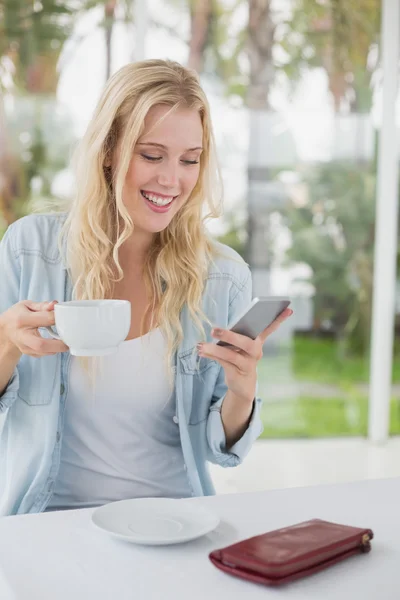 Blonde met koffie verzenden van tekst — Stockfoto