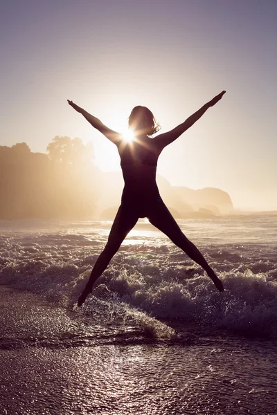 Blonde in sea leaping in bikini — Stock Photo, Image