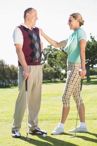 Golfing couple smiling at each other — Stock Photo, Image