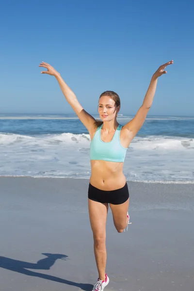 Ajuste mujer estiramiento en la playa — Foto de Stock