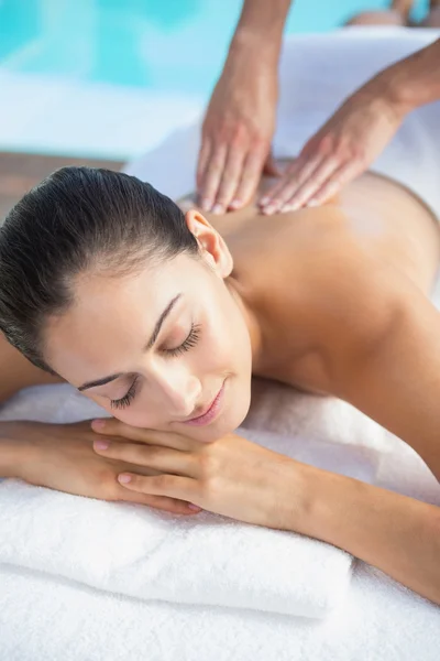 Brunette enjoying a massage poolside — Stock Photo, Image