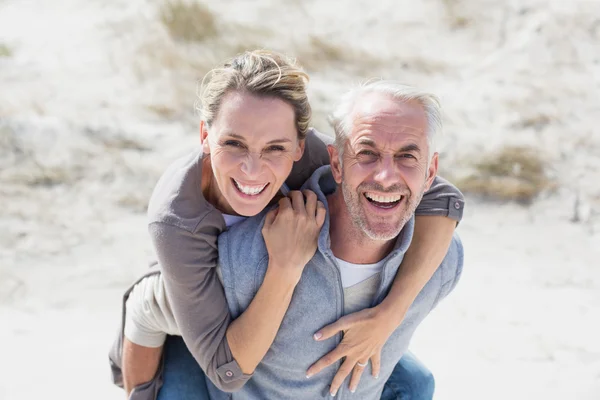 Pareja sonriendo a la cámara en la playa — Foto de Stock