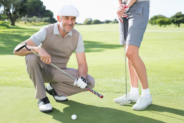 Golfing couple on the putting green — Stock Photo, Image