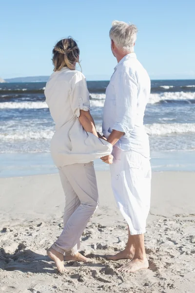 Пара на пляже держатся за руки — стоковое фото
