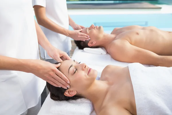 Couple bénéficiant de massages de la tête au bord de la piscine — Photo