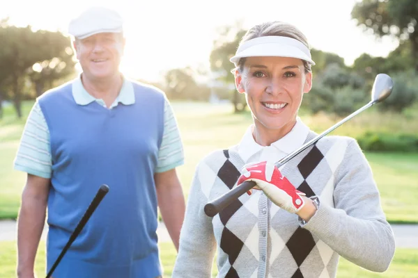 Golfing couple smiling at camera — Stock Photo, Image