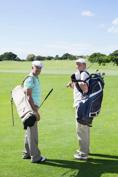 Amis golfeurs tenant leurs sacs de golf — Photo