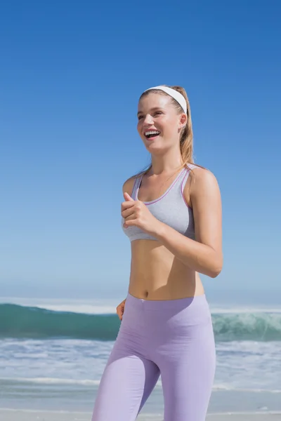 Sportig blondin jogging på stranden — Stockfoto