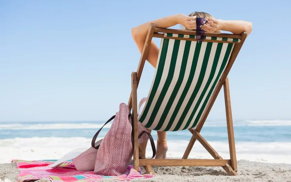 Woman sitting in deck chair — Stock Photo, Image