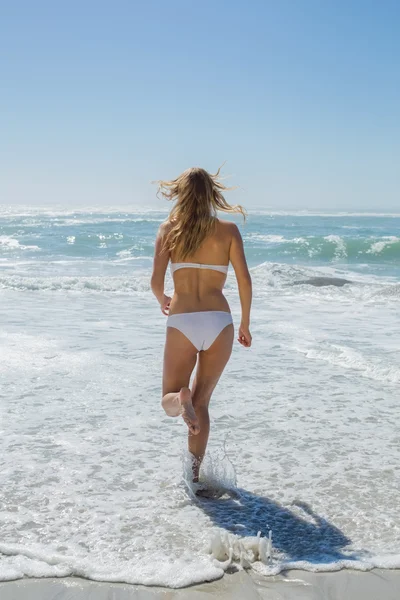 Блондинка бежит к морю — стоковое фото