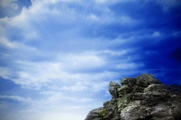 Скала с видом на яркое голубое небо — стоковое фото