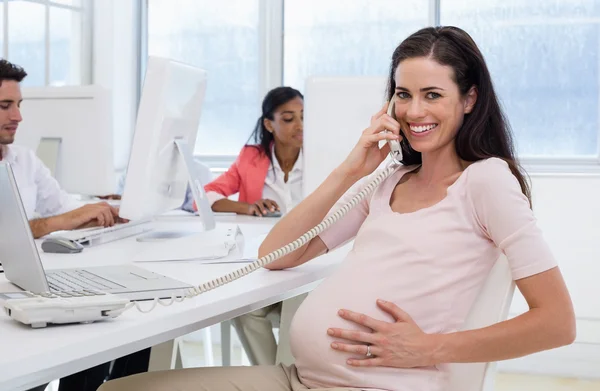 Беременная деловая женщина разговаривает по телефону — стоковое фото