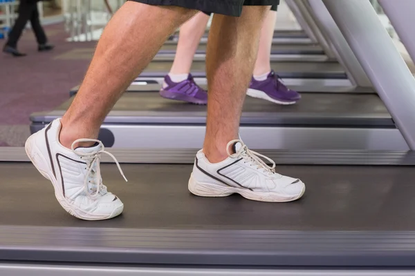 Hombre y mujer caminando en cintas de correr — Foto de Stock