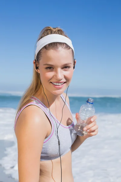 Bionda sportiva sulla spiaggia con bottiglia d'acqua — Foto Stock