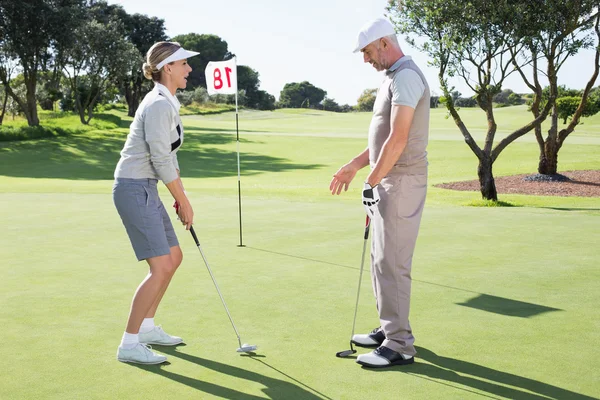 Golfer on the putting green with partner — Stock Photo, Image