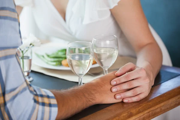 Couple holding hands at dinner — Stock Photo, Image