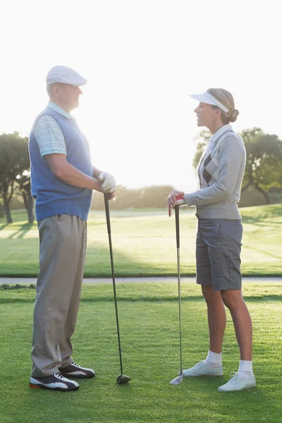 Пара гольфистов стоя и разговаривая — стоковое фото