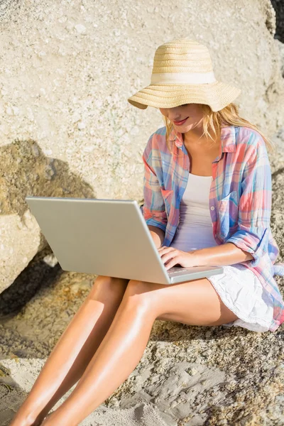 Блондинка с ноутбуком на пляже — стоковое фото