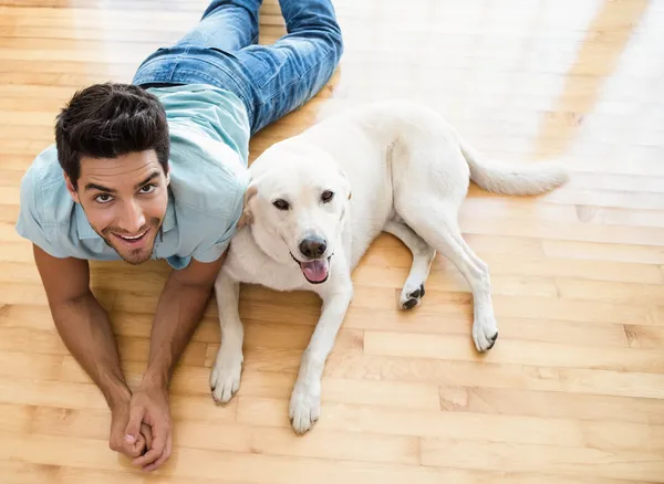 Onun labrador ile katta yatan adam — Stok fotoğraf