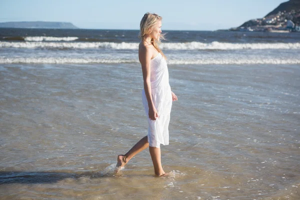 Женщина в белом платье гуляет по морю — стоковое фото
