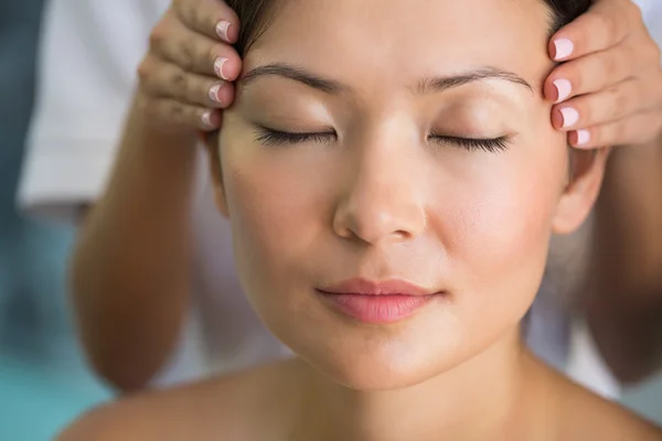 Morena relaxada recebendo uma massagem na cabeça — Fotografia de Stock