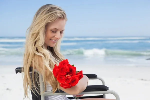 Invalidní vozík vázané blondýnka drží růže — Stock fotografie