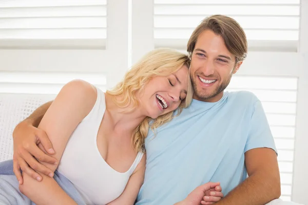 Casal sentado no sofá rindo — Fotografia de Stock