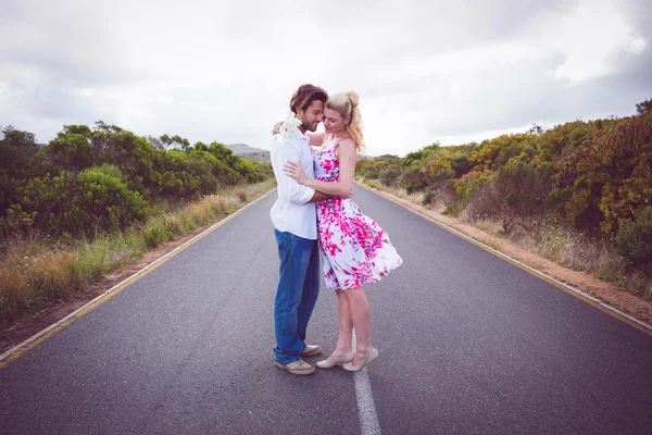 Casal de pé na estrada abraçando — Fotografia de Stock