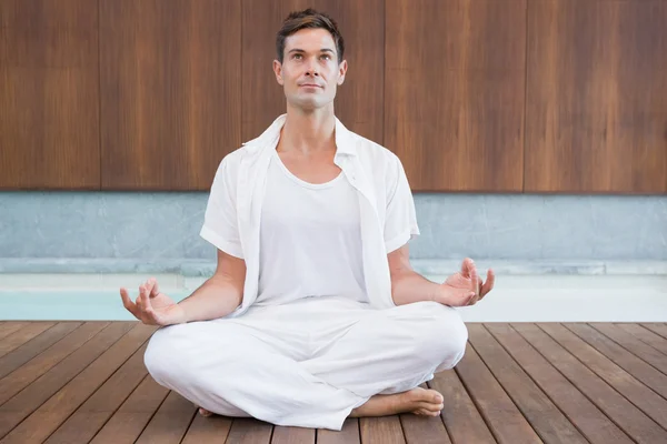 Homem de branco meditando em pose de lótus — Fotografia de Stock