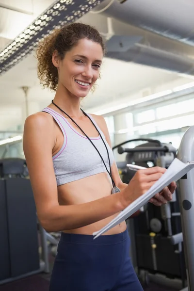 Fitnesstrainerin notiert und lächelt — Stockfoto