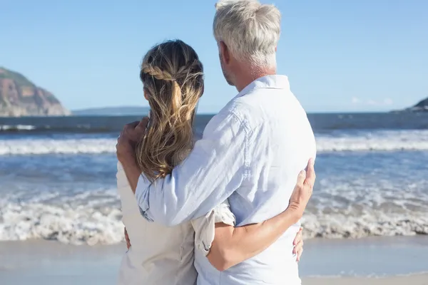 Casal na praia olhando para o mar — Fotografia de Stock