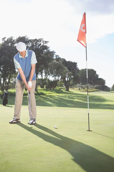 Golfista uvedení míč na greenu — Stock fotografie