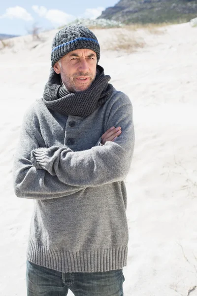 Чоловік тремтить на пляжі в капелюсі і шарфі — стокове фото