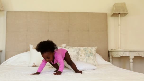 Baby girl standing and falling on bed — Stock Video