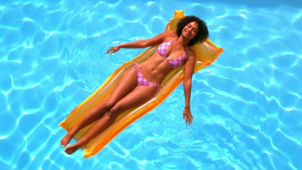Šťastná žena uvolňující na lilo v bazénu — Stock video