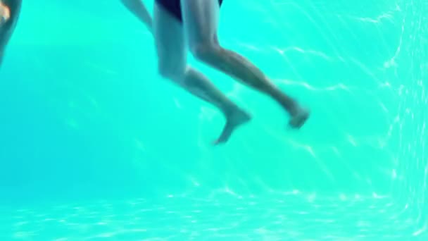 Felice coppia che salta in piscina salutando la fotocamera — Video Stock