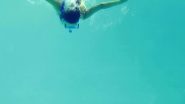 Pretty brunette diving into swimming pool wearing snorkel — Stock Video